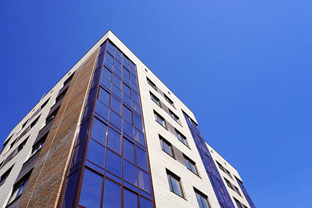 istock Modern newly constructed building, apartment building stretching towards clear blue sky 2217756710