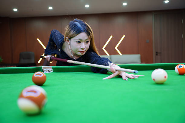 istock Asian woman aiming at billiard ball 2217758392