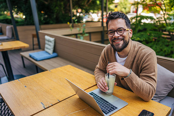 istock Freelancer working on laptop and drinking juice in outdoor cafe 2217758909