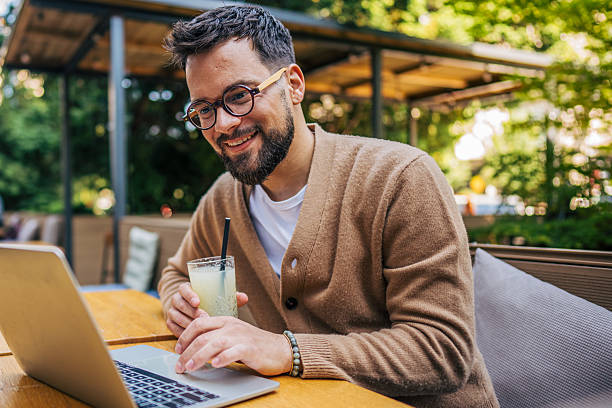 istock Freelancer working on laptop and drinking lemonade in outdoor cafe 2217758910