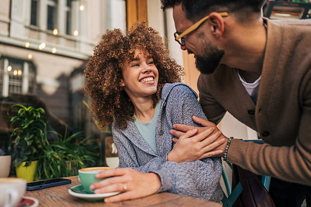 istock Young couple smiling and embracing at a cafe 2217759041