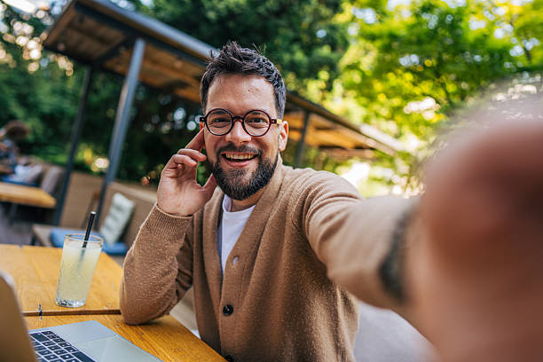 istock Freelancer taking a selfie while working at outdoor cafe 2217759045