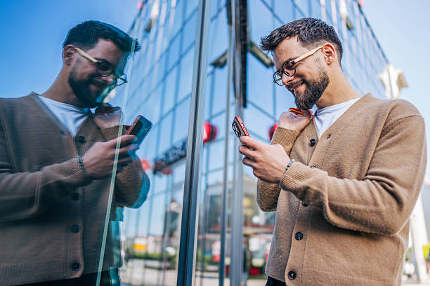 istock Smiling businessman using smartphone near office building 2217759212