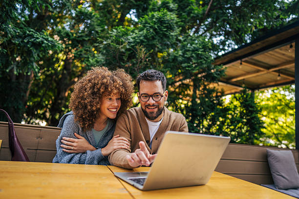 Young couple using laptop in outdoor cafe