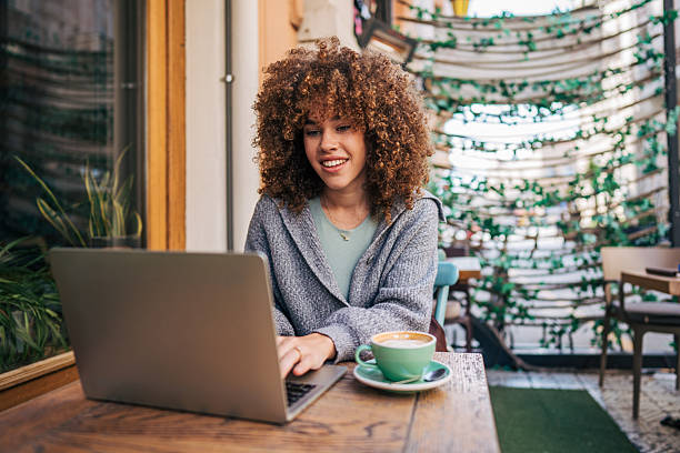 istock Young freelancer working on laptop in outdoor cafe 2217760943