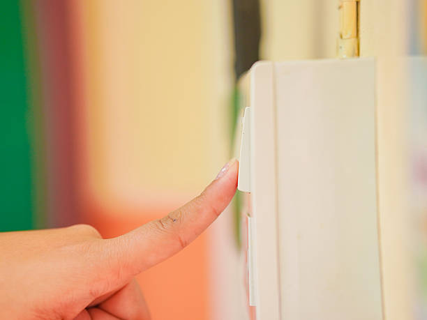 istock Closeup woman's fingers turning off light switch in an office or at home 2217761391