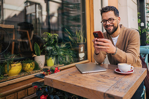 istock Freelancer enjoying a coffee break, working remotely using his phone and laptop 2217761442