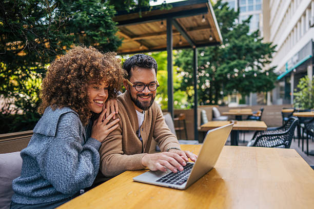istock Young couple working on laptop at outdoor cafe 2217761930