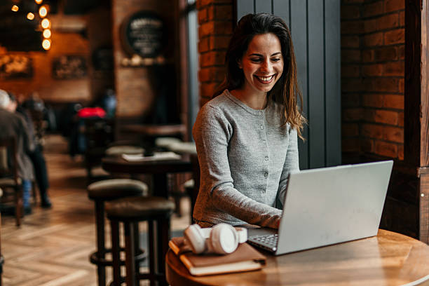 istock Young woman working on laptop in a cafe, enjoying her coffee break 2217763528