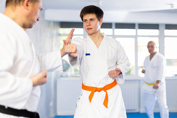 istock Young karate fighter working on punches in sparring with master at training 2217764376