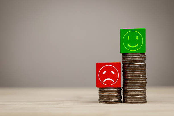 istock Red sad face on stack of small coins and green happy face on stack of big coins. Concept of financial impact assessment, return on investment. 2217773676