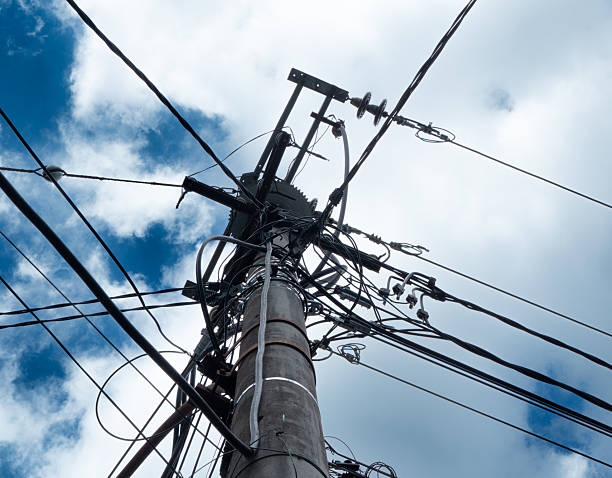 istock electrical infrastructure connection, cables and electric poles with blue sky and white clouds background. 2217782163