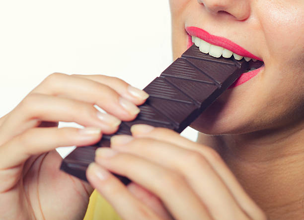 istock Young woman eating chocolate 2217783489
