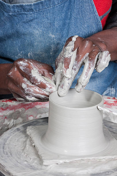 istock mans strong textured hands working with wet clay 2217783818