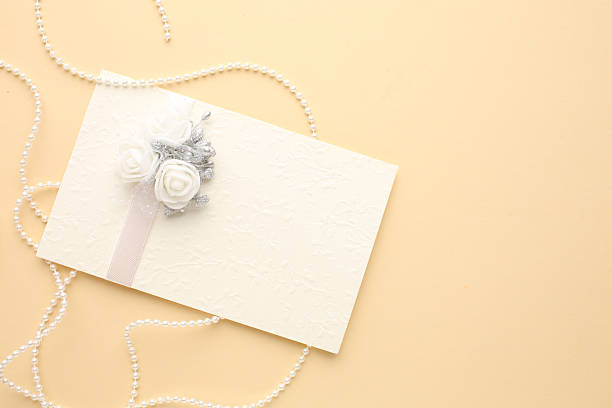 istock Wedding invitations top view. Gift boxes, wedding rings and various wedding trivia on beige table. Background for organising the commemorative date 2217790489