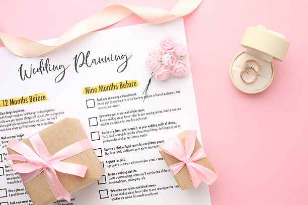 istock Wedding to-do list top view. Gift boxes, wedding planning calendar and various wedding trivia on a pink rustic table. Background for organising the commemorative date 2217790624