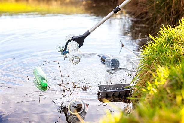 istock Volunteer collecting garbage and litter trash from water environmental conservation 2217792430