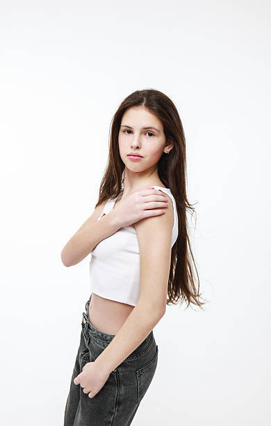 istock Girl in a white top and jeans on a light background. 2217793173