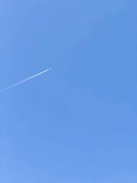 istock Plane with contrail in clear blue sky 2217795392