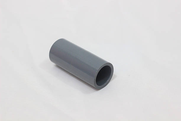 istock A smooth gray plastic pipe sleeve is placed on a white textured surface, shown from an angle that reveals its hollow cylindrical shape. 2217795581