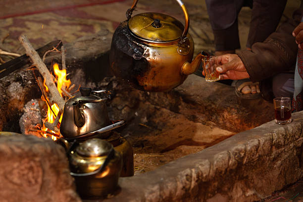 istock Arab Bedouin hand pouring tea from kettle 2217795953