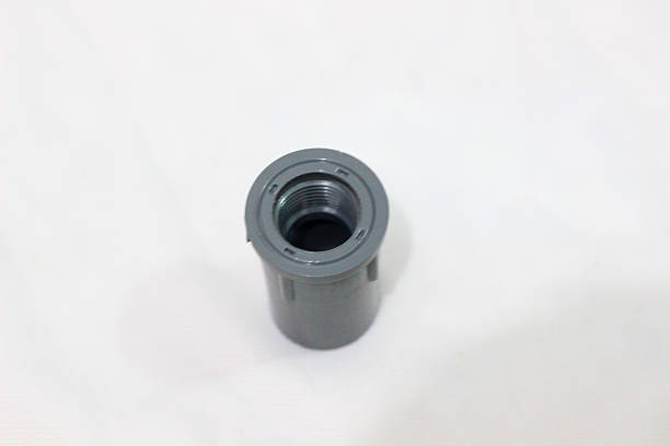 istock A gray plastic pipe fitting with internal threading is shown from the top against a white textured background, emphasizing its cylindrical hollow shape. 2217796078