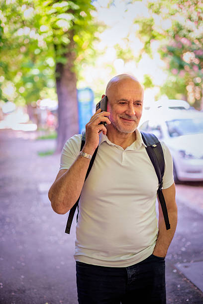 istock Middle aged man walking on the street and using a smart phone 2217801372
