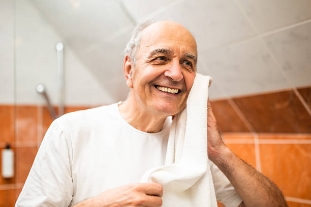istock Joyful older man drying face with towel after washing in bathroom 2217804152
