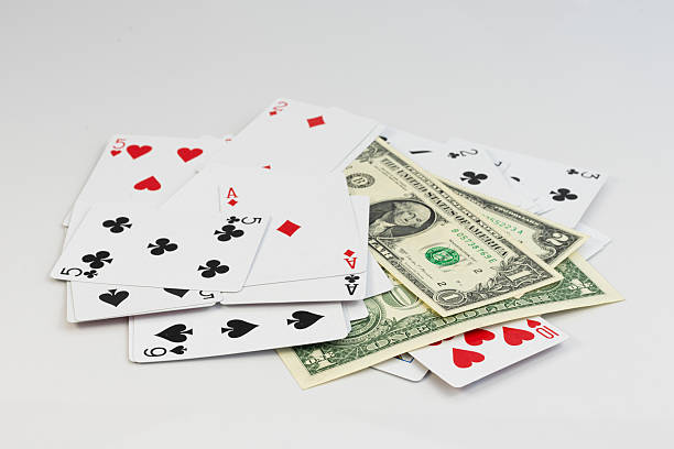 Scattered playing cards and US dollars for gambling concept