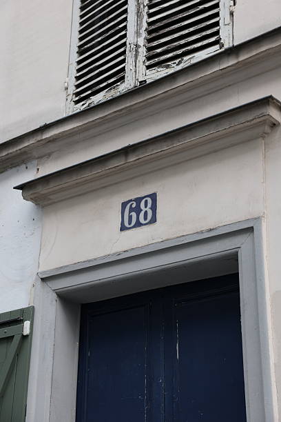 istock Parisian Facade: Blue Enamel Number 68 Above Dark Blue Door with Weathered Shutters 2217805475