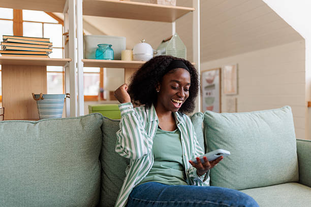 istock Young woman using her phone at home 2217805990