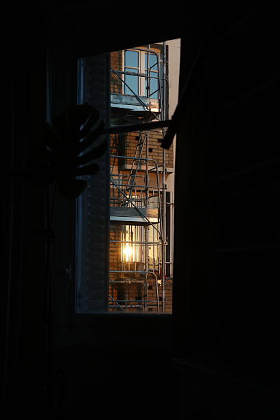 istock Glimpse of Sunset Through Window: Scaffolding on Building Exterior 2217806112