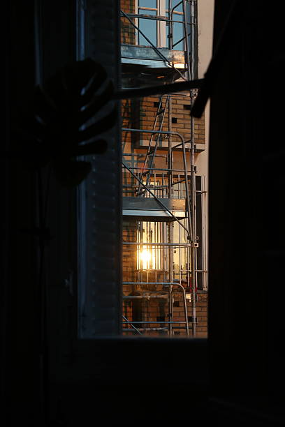 Sunset Flare Through Window: View of Scaffolding on Brick Building