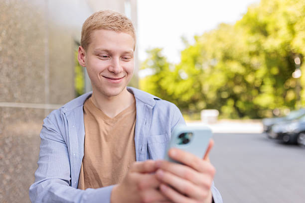 istock Young man using his phone outdoors 2217806477