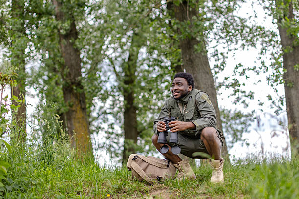 istock Curious young man explores nature with binoculars while bird watching in a serene forest setting 2217806571