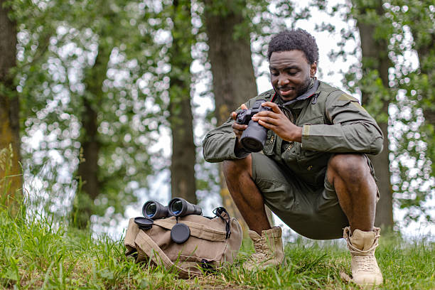 Exploring the beauty of nature through birdwatching with his camera in a serene forest setting