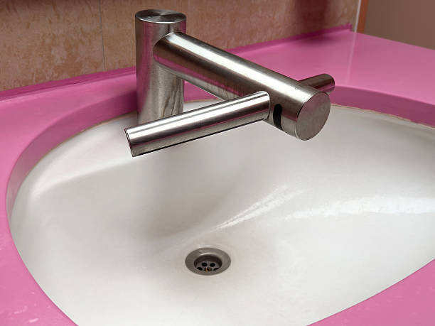 Modern chrome faucet on pink bathroom sink with elegant design, lifestyle