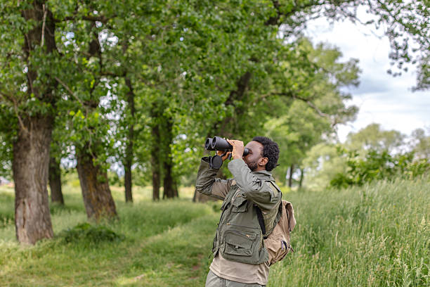 istock Young man bird watching in a lush forest, enjoying nature on a weekend adventure 2217808641