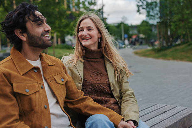 istock Happy couple holding hands and sharing a moment on a park bench 2217809270