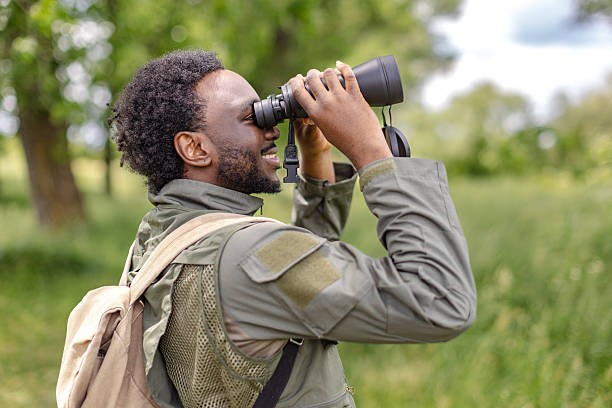 istock Young man enjoying bird watching in a lush forest while exploring nature on a weekend adventure 2217810105