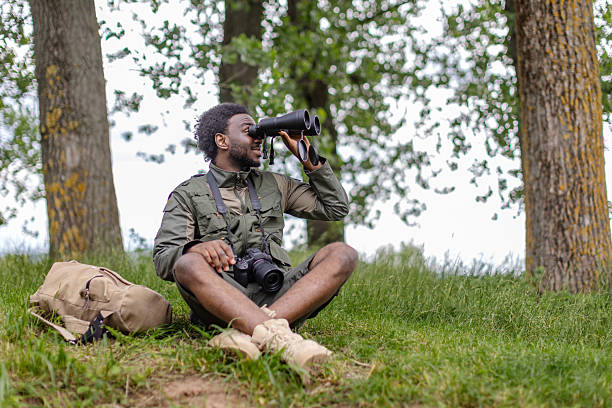 istock Young man enjoying bird watching in a serene forest setting on a sunny weekend 2217810579
