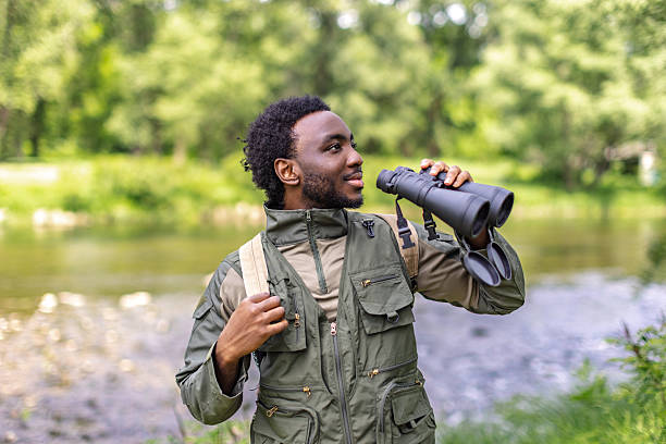istock Young man enjoys bird watching in a lush forest during a weekend adventure, exploring nature's beauty 2217810980