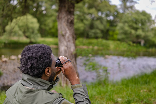 istock Young man enjoys bird watching in a lush forest setting, exploring nature and embracing outdoor adventure 2217811187