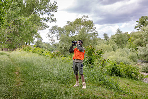 istock Young man enjoys bird watching in a lush forest surrounded by nature and greenery 2217811201