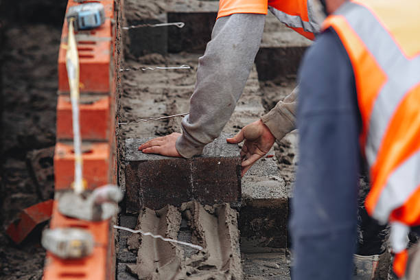 istock Hard-working bricklayer laying concrete blocks on housing site helping eliminate housing crisis by building more affordable houses concept 2217812036