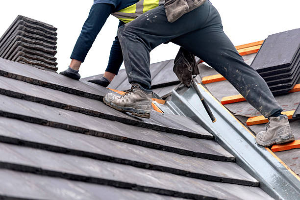 istock Construction worker carefully places roof tiles on a sloped surface while standing on top of a building  showcasing the effort involved in roofing work 2217812038