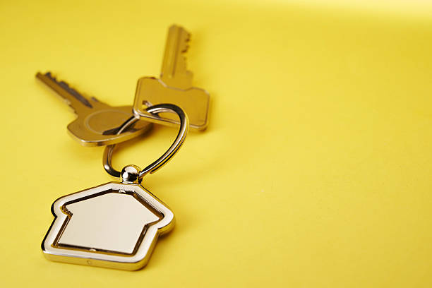 istock house shape keyring and house keys against yellow background 2217812172