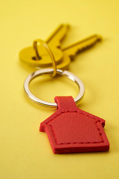 istock house shape keyring and house keys against yellow background 2217812174