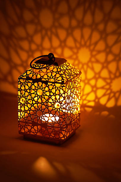 istock Ramadan decoration illuminated arabic lantern against orange background 2217812261