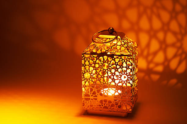 istock Ramadan decoration illuminated arabic lantern against orange background 2217812353